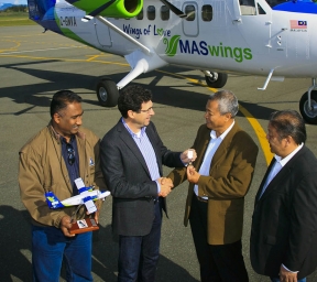 Four men standing in front of aircraft on tarmac