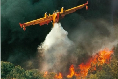 Aerial firefighter dropping water on forest fire